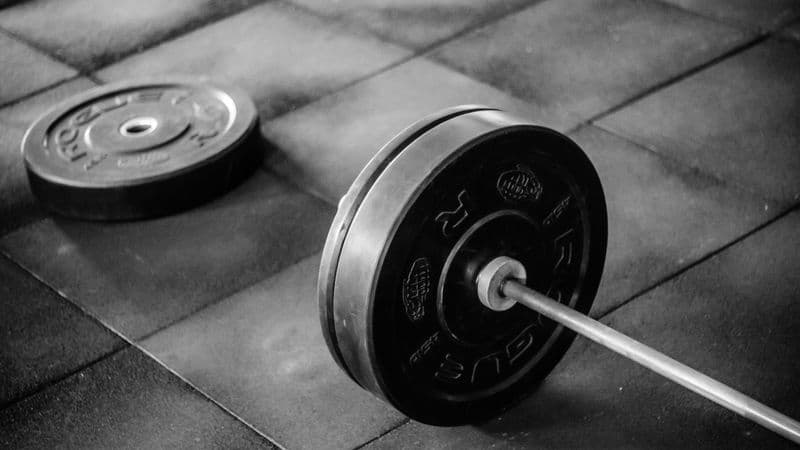 An adjustable dumbbell resting on a gym mat