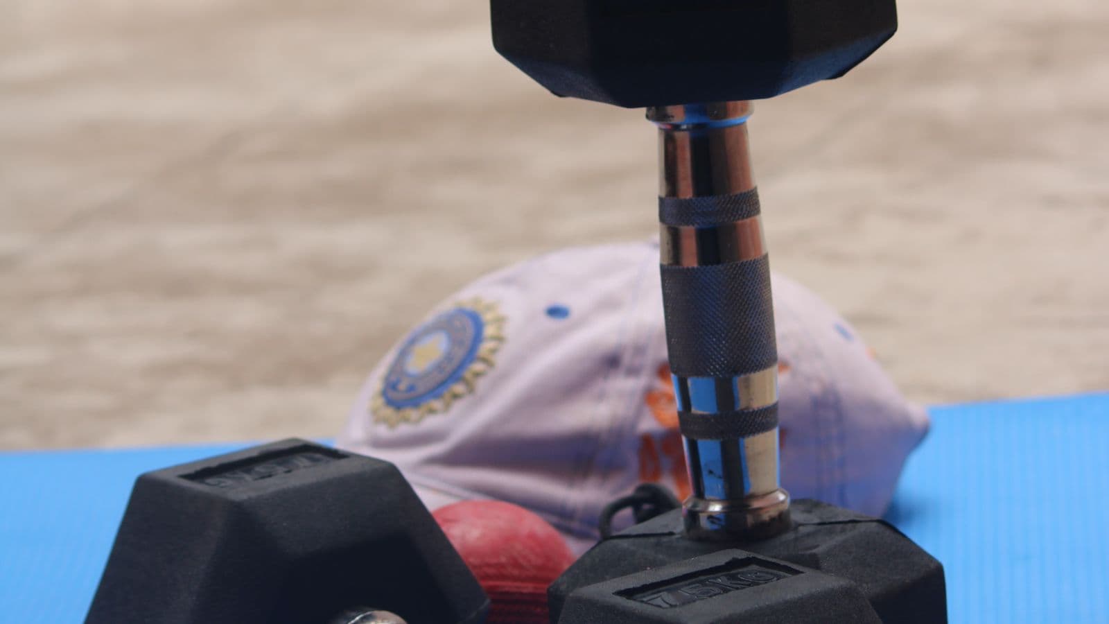 A pair of hex dumbbells resting on a gym mat